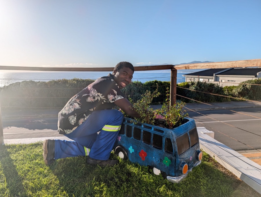 Franco caring for a creative garden planter beside the ocean