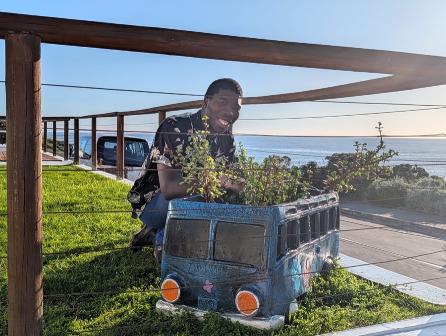 Franco tending a garden planter with an ocean view